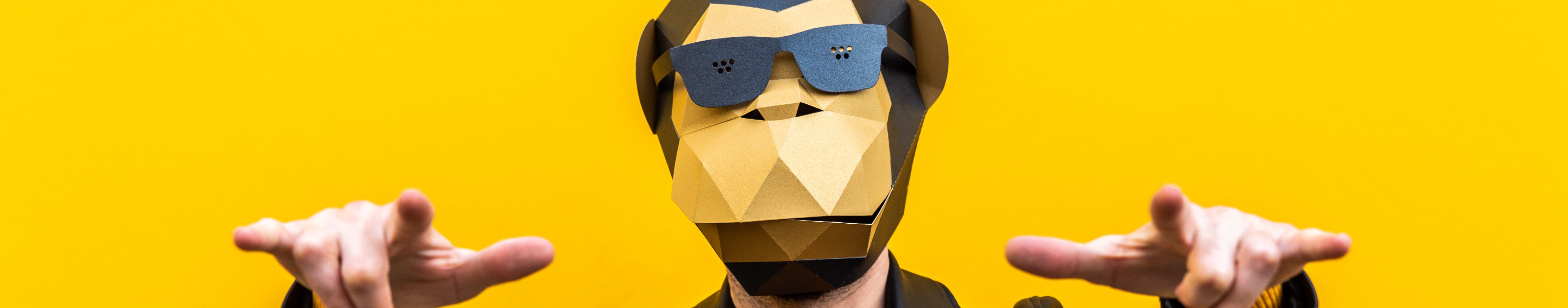 Happy man with funny low poly mask on colored background - Creative conceptual idea for advertising,adult with low-poly origami paper mask doing funny poses